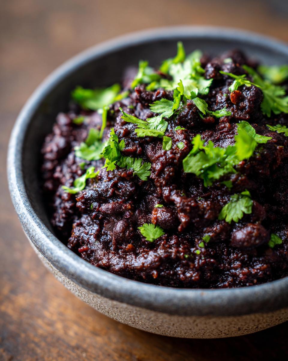 Creamy Black Beans: 30-Min Flavorful Delight 4 Close-up of a bowl filled with creamy black beans recipe, garnished with fresh cilantro.