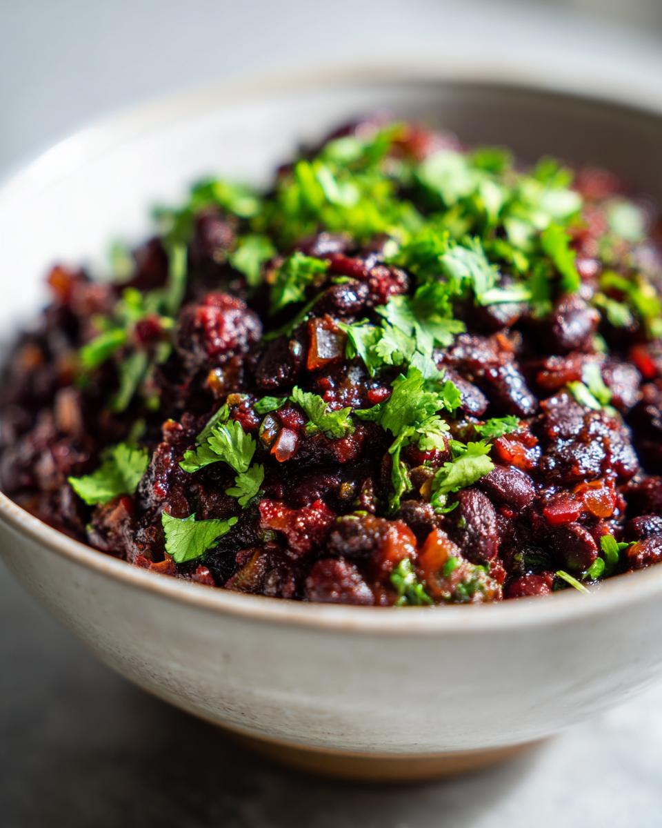 Creamy Black Beans: 30-Min Flavorful Delight 5 Close-up of a bowl filled with creamy black beans recipe, garnished with fresh cilantro.