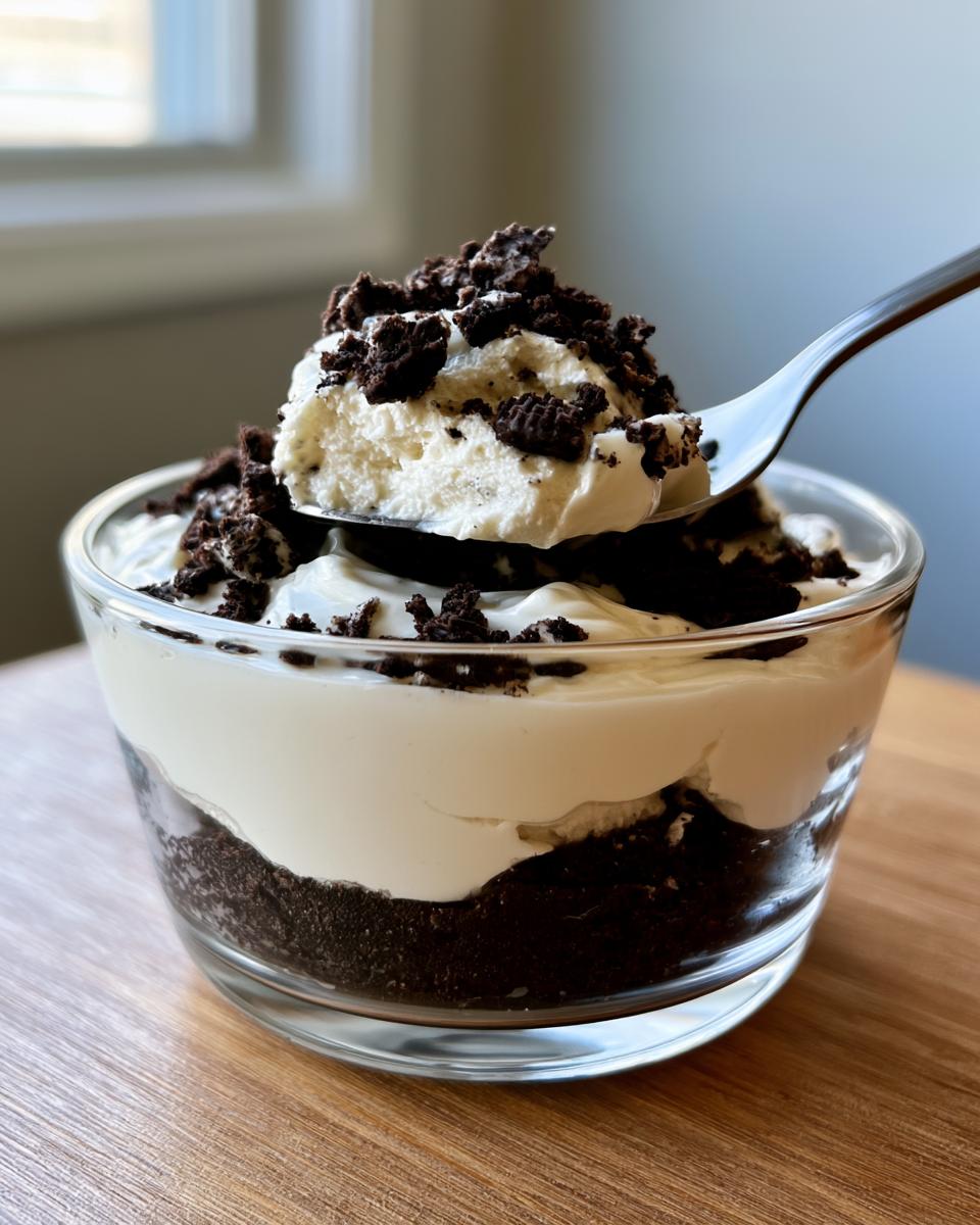 Oreo No-Bake Cheesecake Cups: Heavenly 15-Min Dessert 5 A spoonful of creamy Oreo No-Bake Cheesecake Cups topped with crushed Oreos.