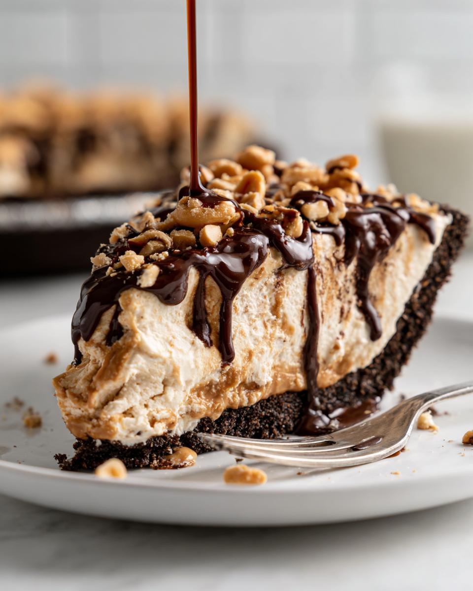 Irresistible Peanutty Ice Cream Pie 4 A decadent slice of Peanutty Ice Cream Pie, drizzled with chocolate sauce and topped with peanuts.